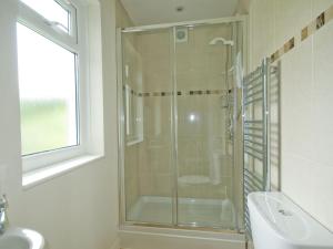 a bathroom with a glass shower and a sink at The Meadow in Feock