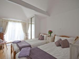 a bedroom with two beds and a large window at Rosemaddon in Crantock