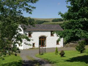 a white stone house with a door in the middle at Middlefell View Cottage in Alston