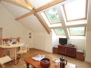 a living room with a table and a dining room with windows at Mithian Cottage in St. Agnes