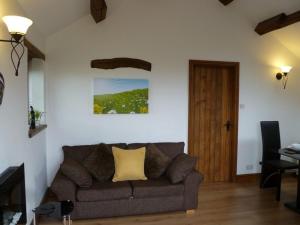 a living room with a couch and a wooden door at Buttercup Cottage in Penrith