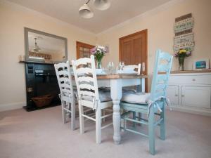 uma sala de jantar com uma mesa e quatro cadeiras em Bay View House em Crantock