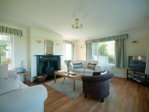 uma sala de estar com um sofá e uma mesa em Bay View House em Crantock