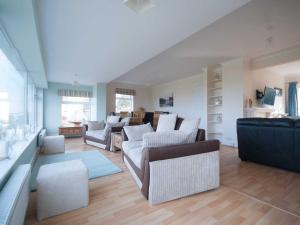 a living room with several couches and chairs in it at Crantock Bay House in Crantock
