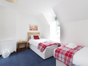 a bedroom with two beds and a table in it at Dunnottar Woods House in Stonehaven