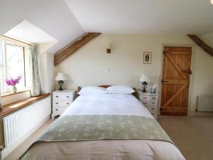 a bedroom with a large bed and a window at Chilvery Farm Cottage in Okehampton
