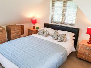 a bedroom with a large bed and two night stands at Riverside Lodge in Norton
