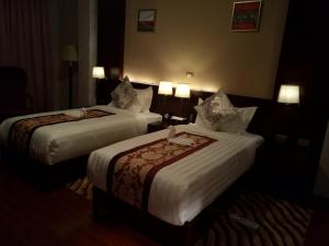 a hotel room with two beds with white sheets at Sherar Addis Hotel in Addis Ababa