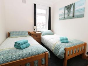 מיטה או מיטות בחדר ב-Sands End Cottage
