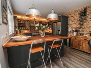 a kitchen with a wooden counter with two stools at 11 Highfield in Scarborough