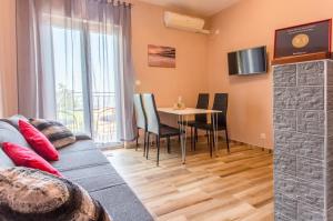 een woonkamer met een bank en een tafel met stoelen bij Apartments Dalmatia Blue in Mlini