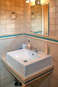 een badkamer met een witte wastafel en een spiegel bij The Springs in Ryde