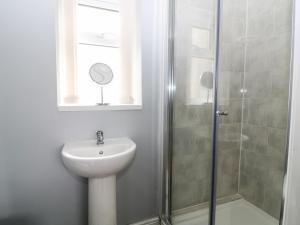 a bathroom with a sink and a shower at Felin Manaw in Bryngwran