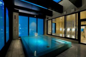 una piscina en un edificio con vistas a la ciudad en Candeo Hotels Tokyo Roppongi, en Tokio