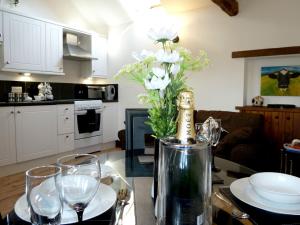 uma mesa com uma garrafa de champanhe e alguns copos em Daisy Cottage em Penrith