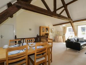 una sala da pranzo e un soggiorno con tavolo e sedie. di Carpenters Cottage a Cockermouth