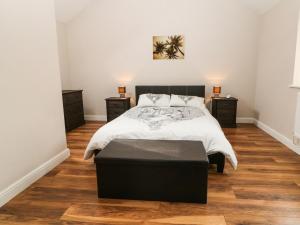 a bedroom with a bed and two night stands at Felin Manaw in Bryngwran