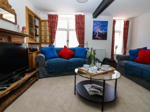 a living room with a couch and a tv at Medland in Newton Abbot