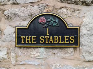 a sign on the side of a stone wall at 1 The Stables in Clitheroe