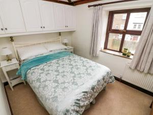 1 dormitorio con cama y ventana en 1 The Stables en Clitheroe