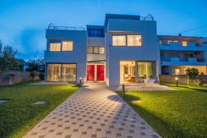 a large white house with a lawn in front of it at CAISA- luxury apartment 20 m from the sea in Zadar