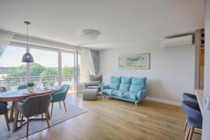 ein Wohnzimmer mit einem blauen Sofa und einem Tisch in der Unterkunft Penthouse in Druskininkai