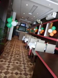 a dining room with white tables and green balloons at Buddha Imperial in Muzaffarpur