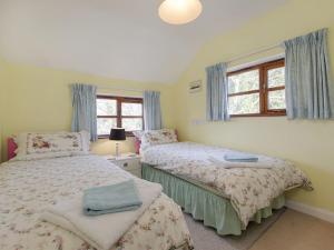 a bedroom with two beds and a window at The Annexe, Higher Lydgate Farmhouse in Postbridge