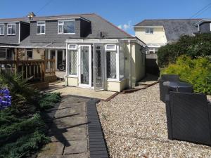 a house with a porch and a patio at Peonies in Exmouth