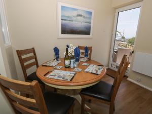 a dining room with a table and chairs and a window at Sea View in Benllech +19 photos