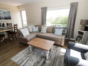 a living room with a couch and a table at Sea View in Benllech