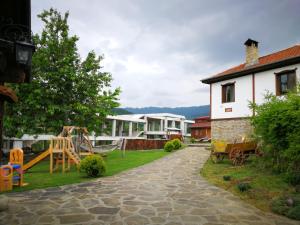 un patio con parque infantil y una casa en Guest House Stoilite, en Boazat