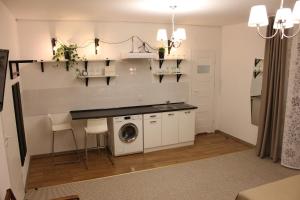 a kitchen with a washer and dryer in a room at Kolorowa Guest Rooms in Warsaw