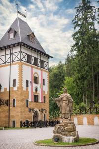 a statue of a man in front of a building at Zámek Lužec Spa & Wellness Resort in Karlovy Vary