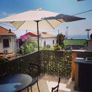 a patio with a table and an umbrella at Casa Aurora in Taormina