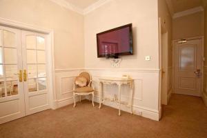 een kamer met een tafel en een tv aan de muur bij The Blueberry Hotel in Pontypridd