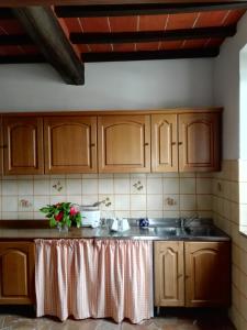a kitchen with wooden cabinets and a table with flowers on it at Casa Giulia in Ronta