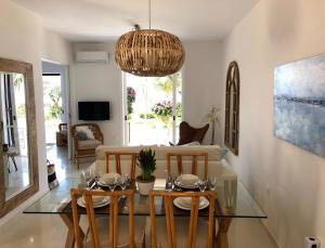 a living room with a table and chairs and a chandelier at Aqua Seafront Glyfada Corfu Beach House With Garden in Glyfada