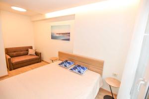a small room with a bed and a chair at Jūra in Palanga +3 photos