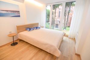 a bedroom with a bed and a large window at Jūra in Palanga