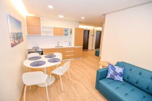 a living room with a blue couch and a table and chairs at Jūra in Palanga