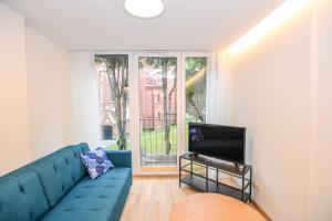a living room with a blue couch and a tv at Jūra in Palanga