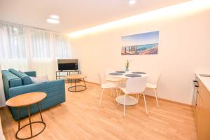 a living room with a blue couch and a table and chairs at Jūra in Palanga