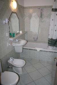 a bathroom with a toilet and a sink and a shower at Hotel Bouček in Mochov