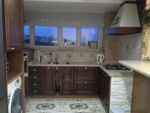 a kitchen with a sink and a stove and windows at Аппартаменты с видом на залив in Cheboksary
