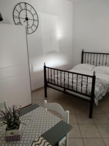1 dormitorio con 2 camas, mesa y reloj en Apartments Anica, en Rovinj