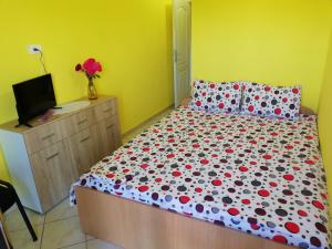 1 dormitorio con 1 cama y vestidor con TV en Smeštaj - sobe MARVEL, en Niš