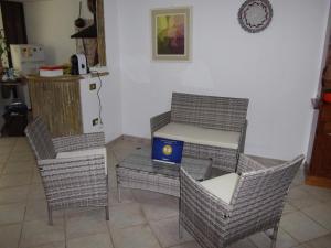 una cocina con 3 sillas y una mesa con una caja azul en Casa S'Arriali, en Iglesias