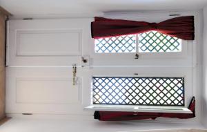 a white garage door with a window with a red bow at Margarita Hotel in Kythira