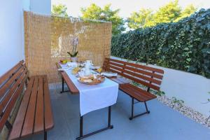 a table and two benches on a patio at Apartments Lola in Rogoznica